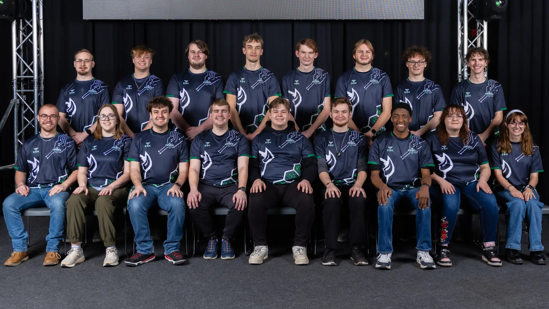 Five members of the Esports Club pose together, wearing matching navy and green ESK Esports jerseys.
